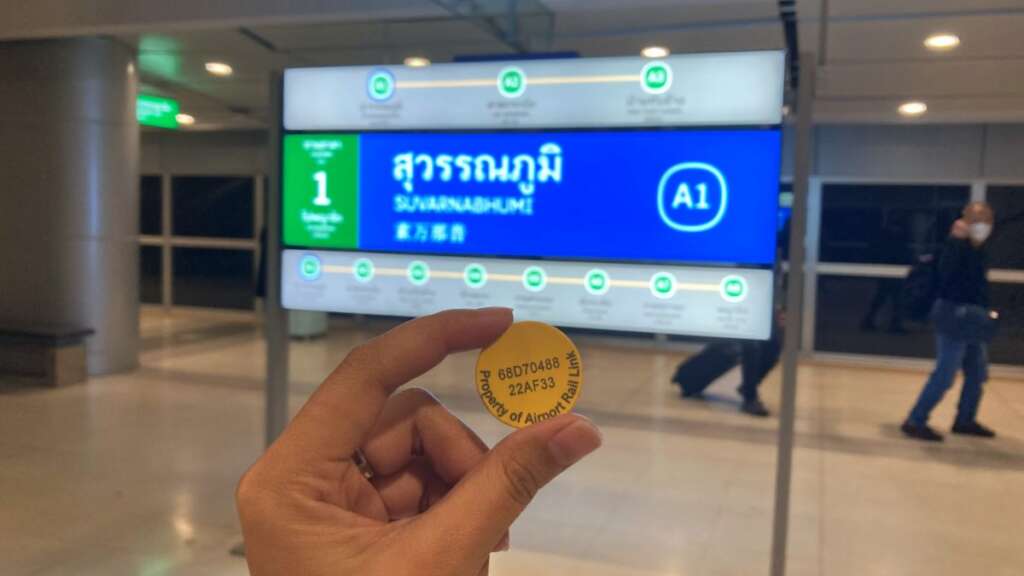 menunjukkan koin airport railink di stasiun bandara